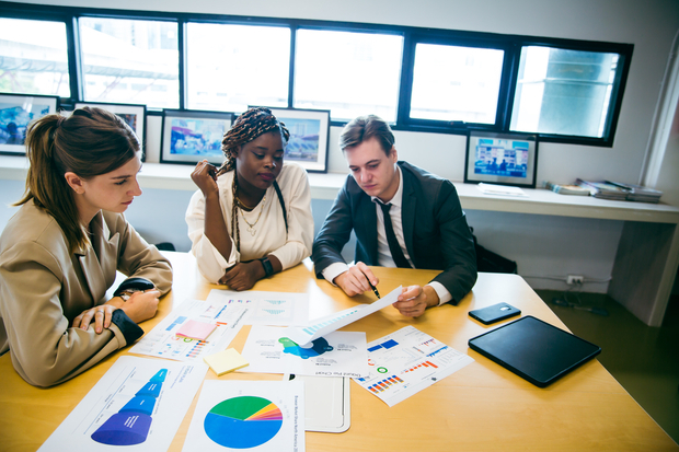 Economist with students reviewing a range concerns to track economic areas of focus