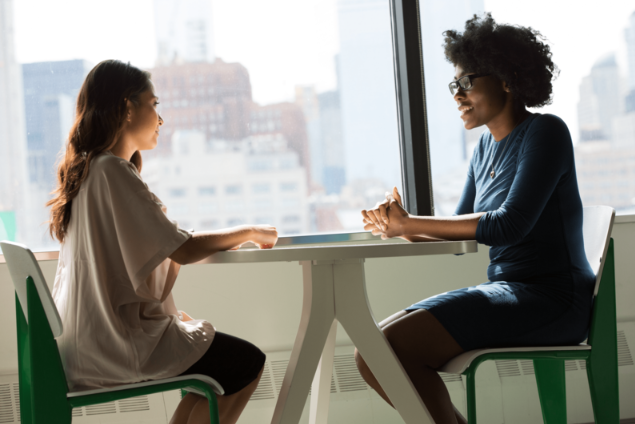 Two women having a conversation about career anxiety.