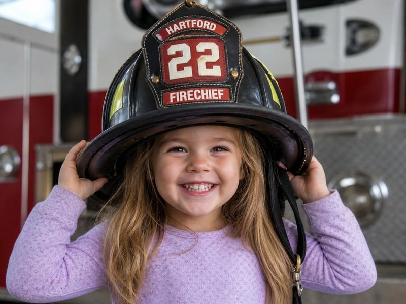 little girl in a fireman hat