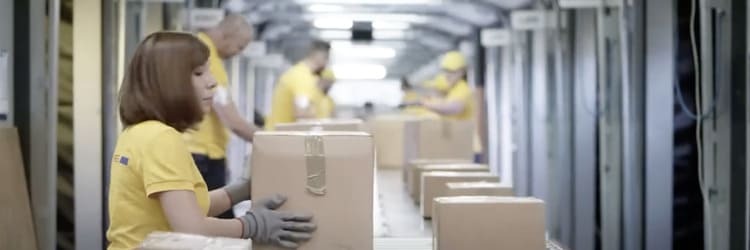 Laborer putting box onto conveyor belt