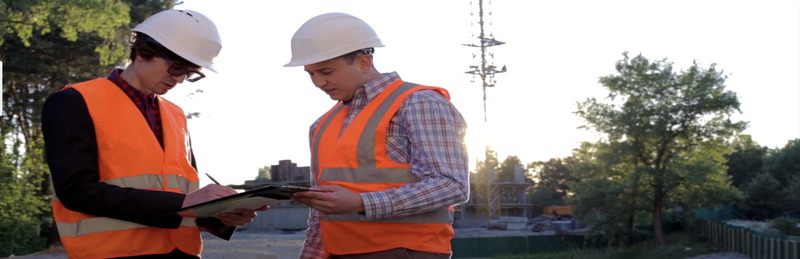 two men with hard hats discussing environmentally friendly job