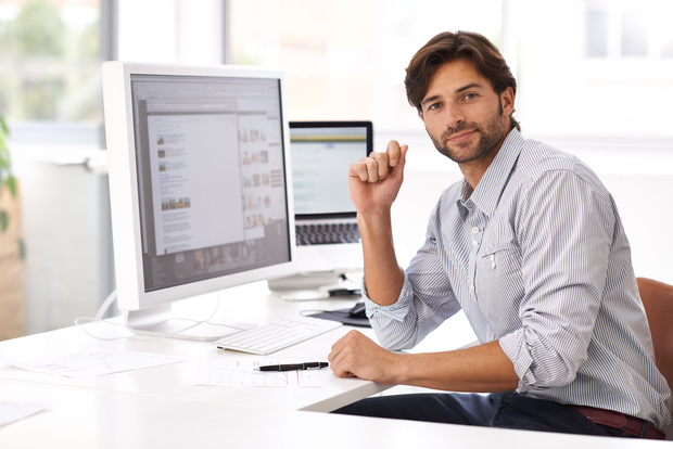 Computer and Information Systems Manager engaging in remote work with computer in the background and screen open to website browser