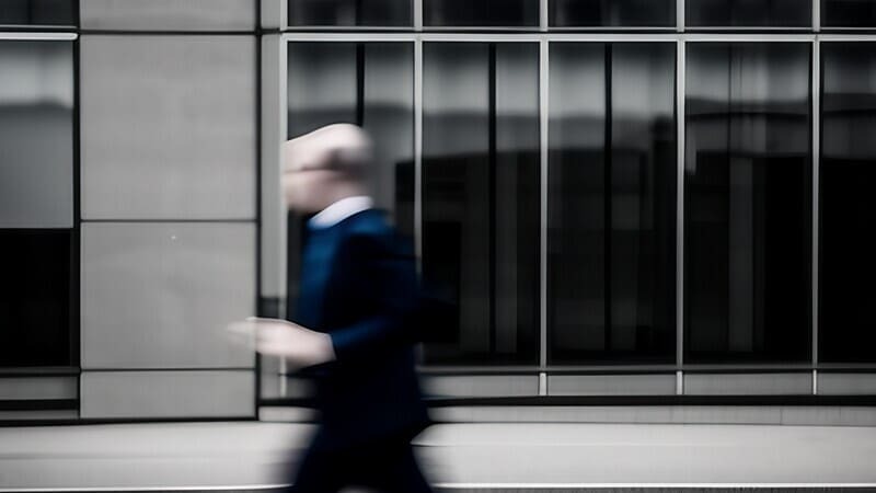 graduate in business suit running to next job