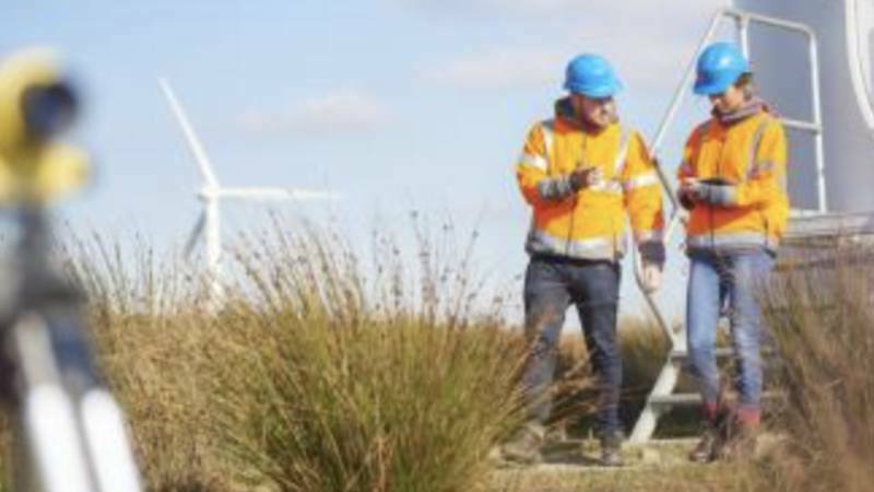 Wind turbine service technician working on wind turbine in field